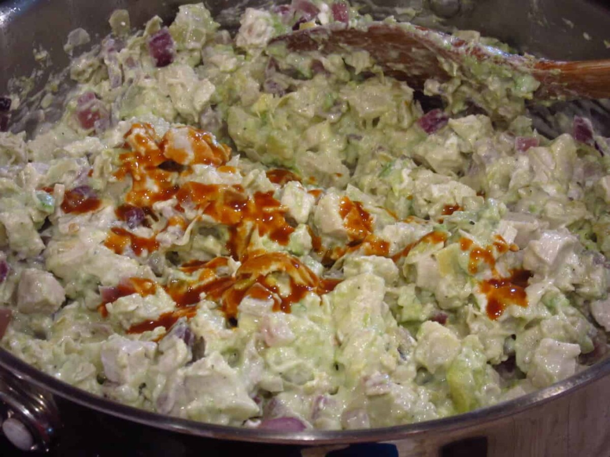 Hot sauce in a bowl of creamy chicken artichoke pasta sauce.