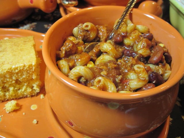 turkey chili mac in an orange bowl with a spoon.