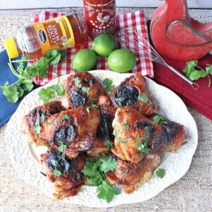 A platter of honey lime siracha chicken thighs topped with cilantro.