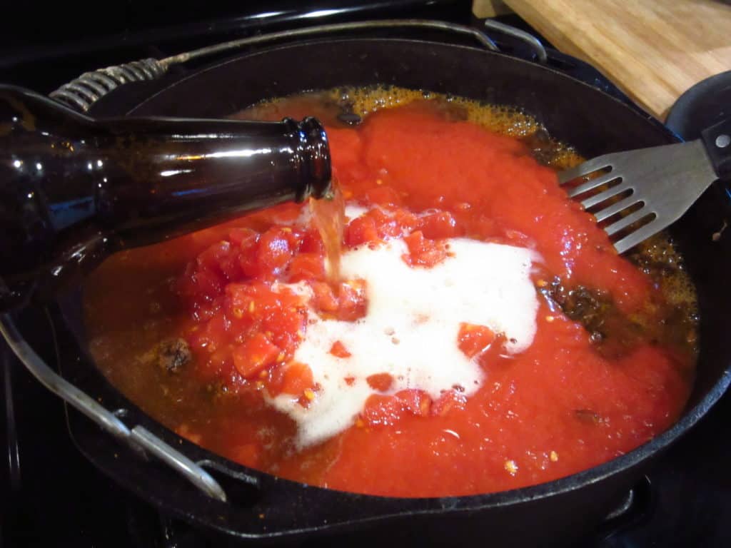 Beer being added to a pot of Mole chili.
