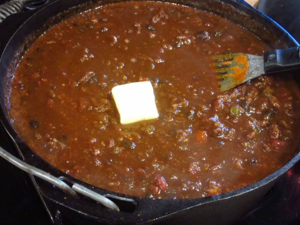 A pat of butter in a pot of Mole turkey chili.
