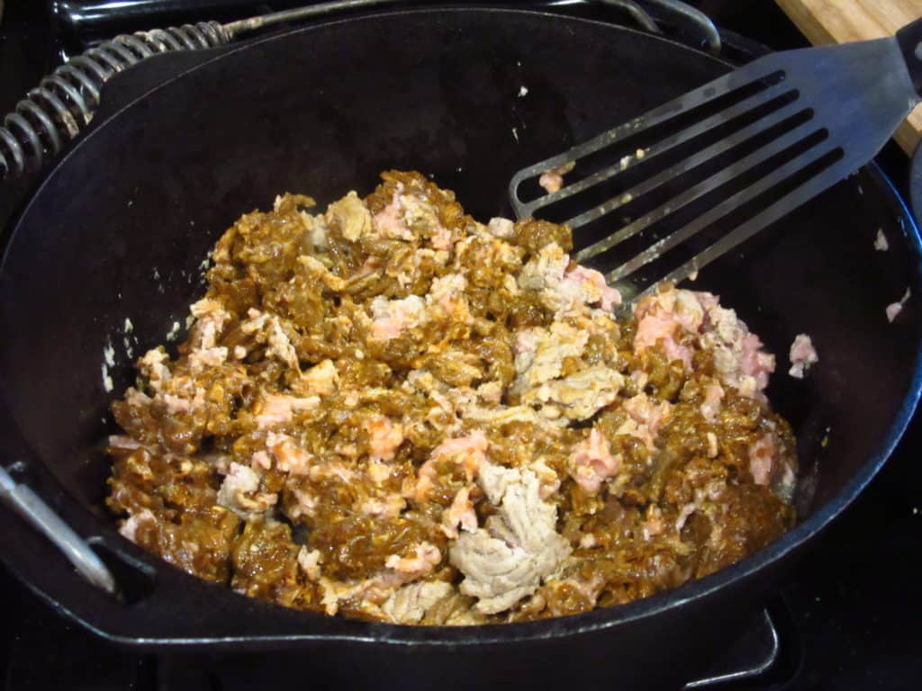 Ground turkey and spices in a cast iron Dutch oven.