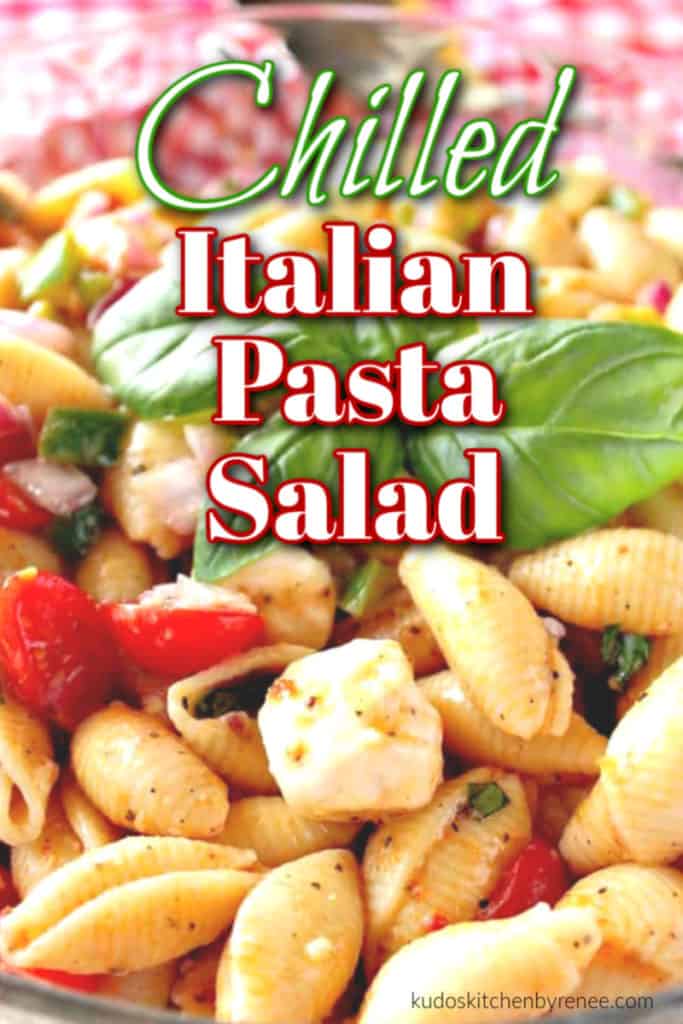 Closeup photo of a chilled Italian pasta salad with basil and tomatoes with a title text overlay graphic