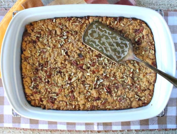 Overhead horizontal photo of a 13 x 9 baking dish filled with hazelnut spread cookie bars with a silver serving spatula on top.