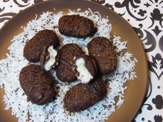 An overhead horizontal photo of homemade almond joy candy on a brown plate with coconut.