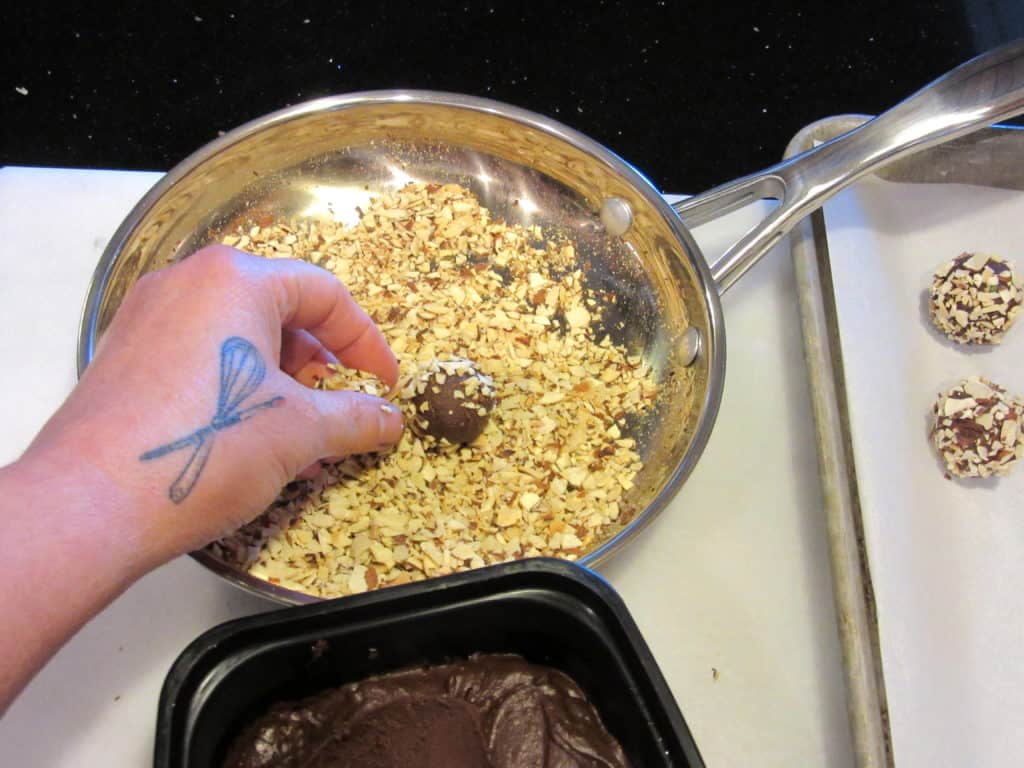 Rolling chocolate truffles in nuts.