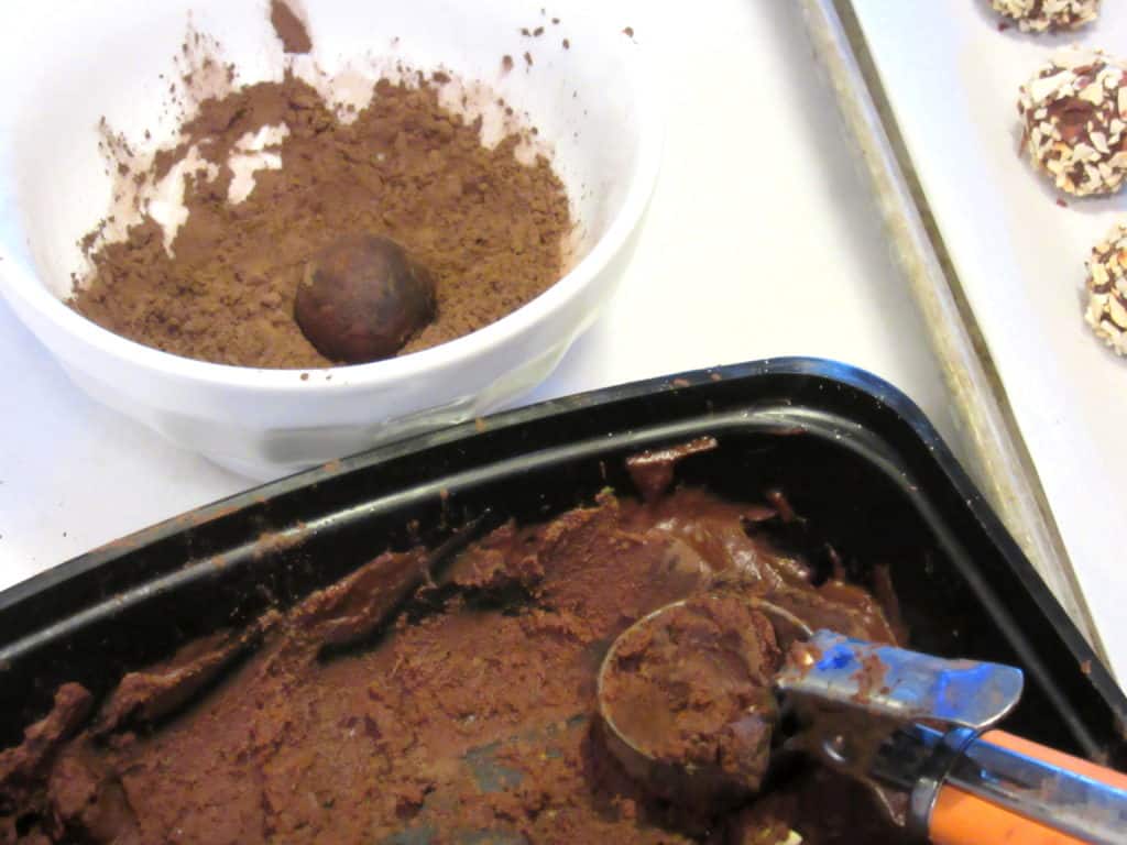 Chocolate truffles being scooped from a dish.