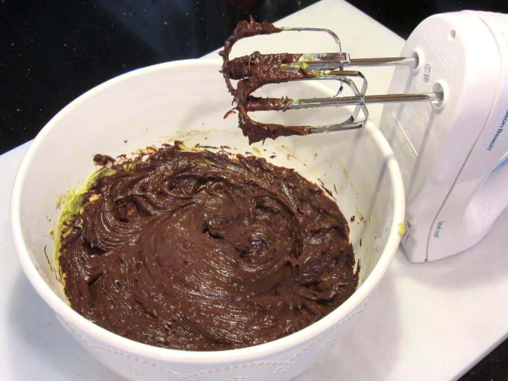 A hand mixer with a bowl of truffle mix.
