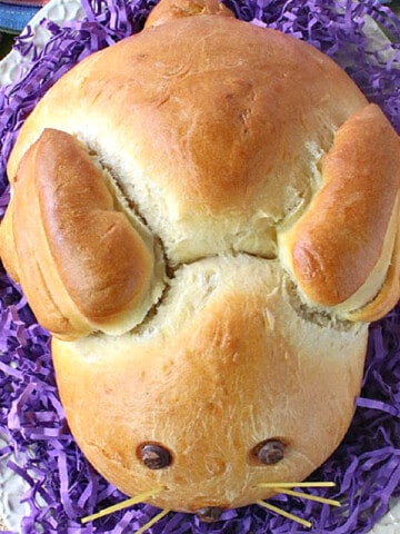 An overhead photo of a loaf of Bunny Bread for Easter on a bed of purple grass.