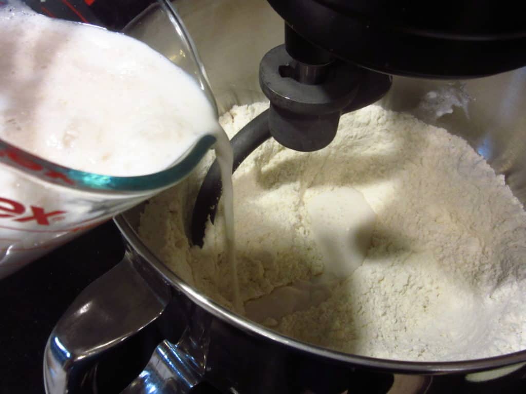 Milk being added to a mixing bowl.