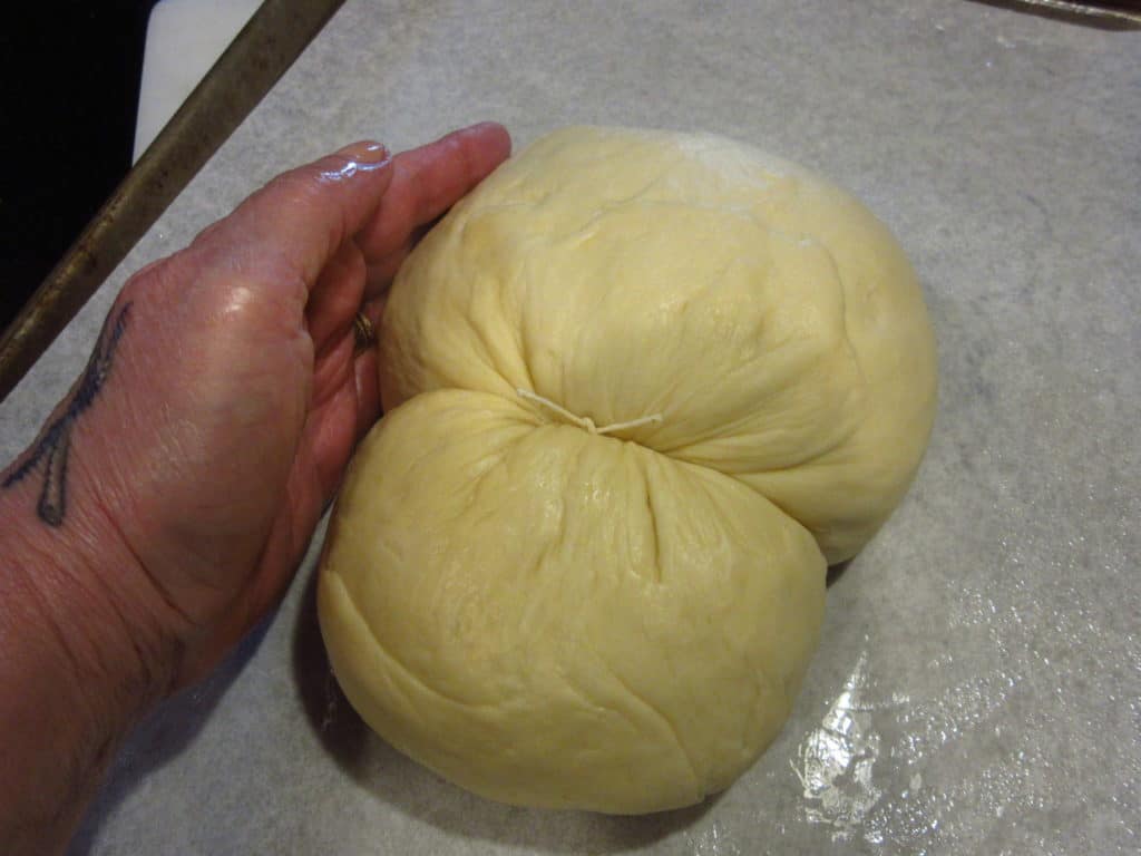 A hand forming dough.