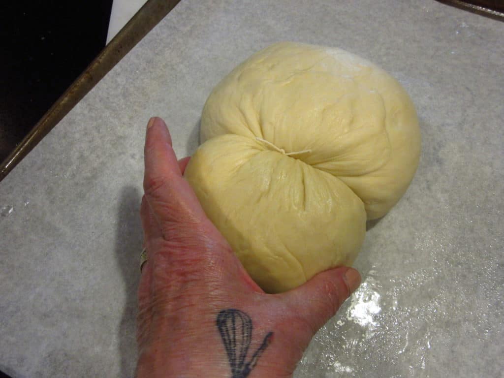 A hand forming the head of bunny bread.