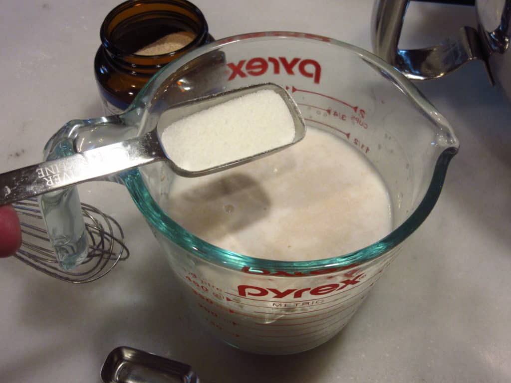 Sugar being added to a measuring cup.