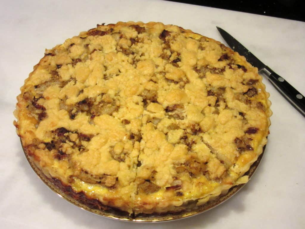 A baked Irish Cheese and Potato Tart with a slice ready to be taken out.