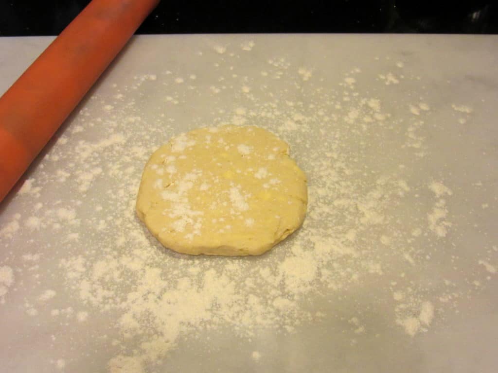 A disc of tart dough on a floured surface.