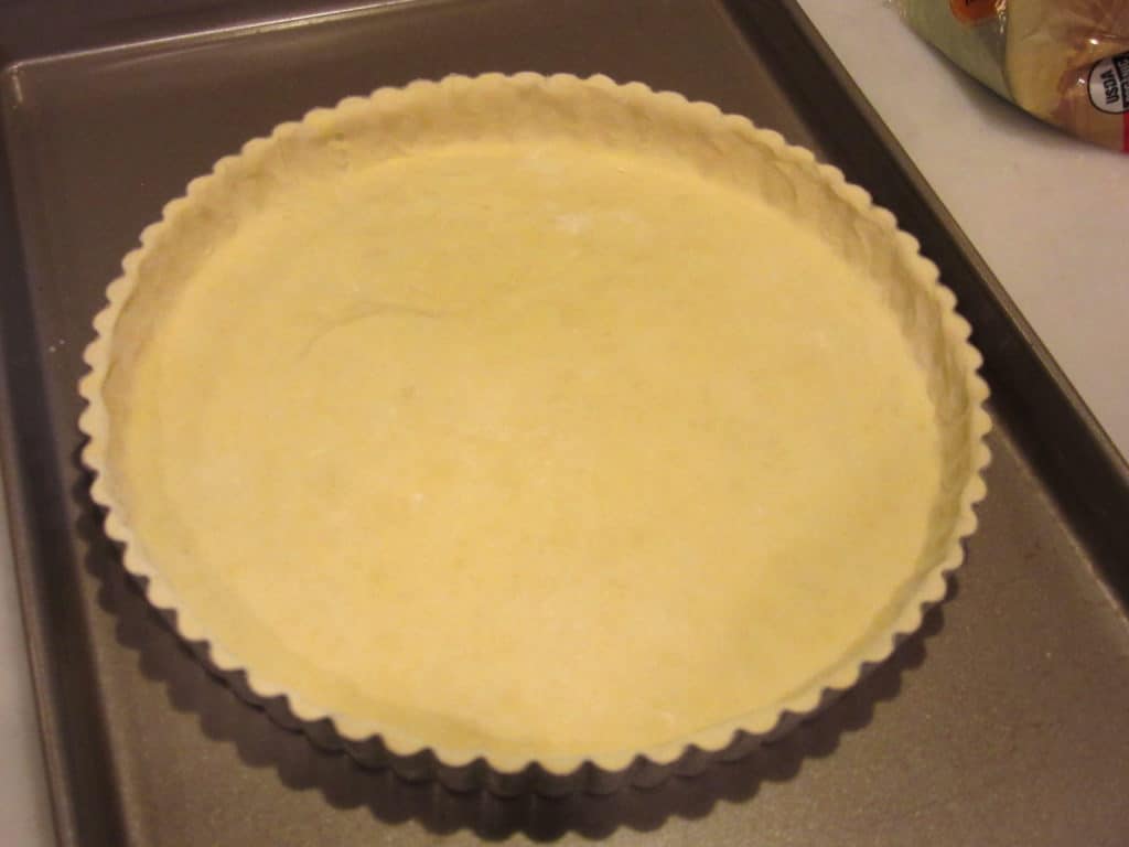 A neat tart dough in a tart pan before baking.