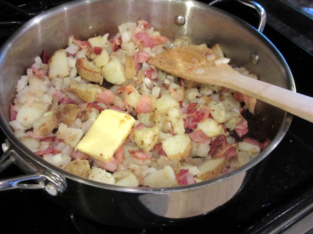 Potatoes and bacon in a skillet with butter.