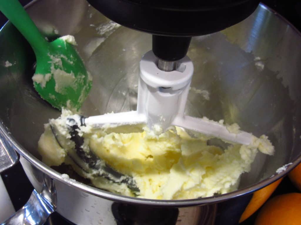 A spatula in a stand mixer bowl with creamed butter.