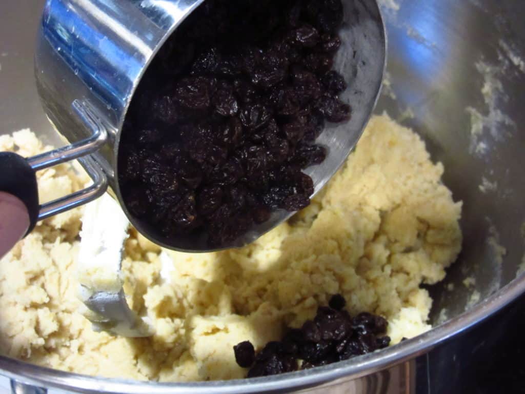 Currants being added to a cookie dough.