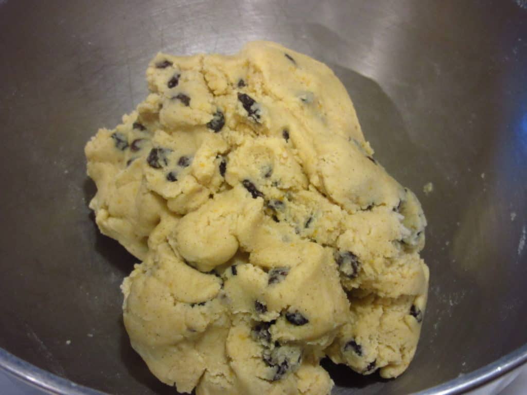 A cookie dough with currants in a bowl.