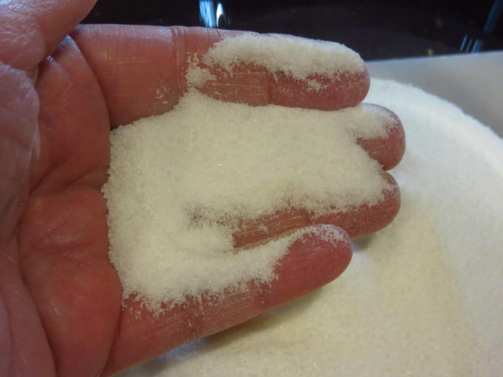 A hand in some castor sugar to show consistency.