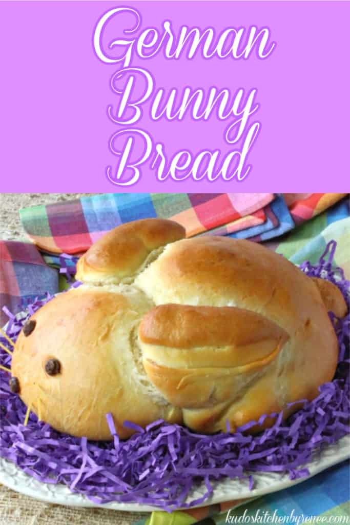 A vertical closeup photo of German bunny bread sitting on purple Easter grass with colorful text.