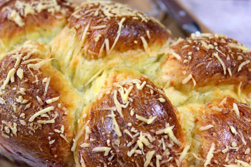 Closeup photo of a golden brown loaf of braided Italian Easter cheese bread.