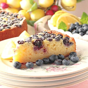 A slice of Lemon Ricotta Cake with Blueberries on a pretty china plate.