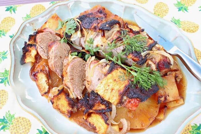 Overhead photo of pineapple pork tenderloin on a platter with fresh cilantro.