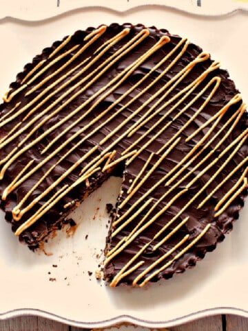 A Giant Peanut Butter Cup with Toasted Coconut and Pecans on a plate with a wedge removed.