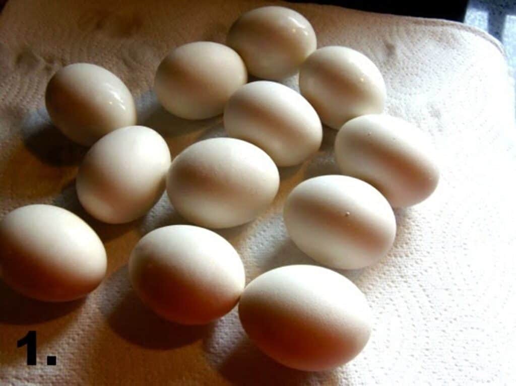 One dozen hard boiled eggs on a cloth.
