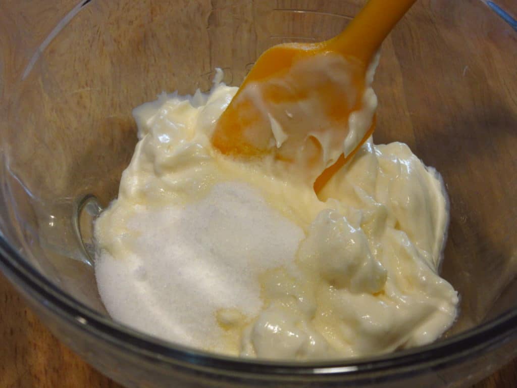 Mayo and sugar in a bowl with a spatula.