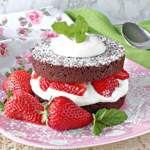 A brownie Strawberry Shortcake on a pink plate.