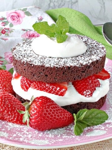 A brownie Strawberry Shortcake on a pink plate.