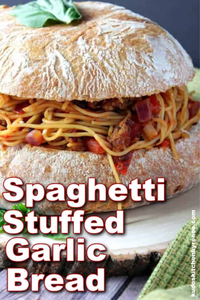 Closeup vertical photo of spaghetti stuffed garlic bread with title text and fresh basil.