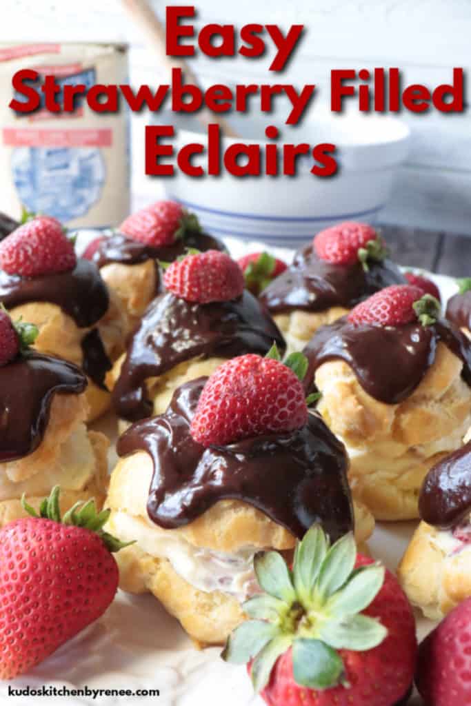 Closeup title text image of strawberry filled eclairs with chocolate ganache topping and fresh strawberry garnish.