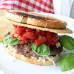 A Bruschetta Burger on Italian Bread with tomatoes, basil, and a Parmesan crisp.