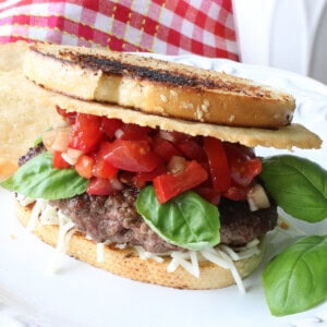 A Bruschetta Burger on Italian Bread with tomatoes, basil, and a Parmesan crisp.