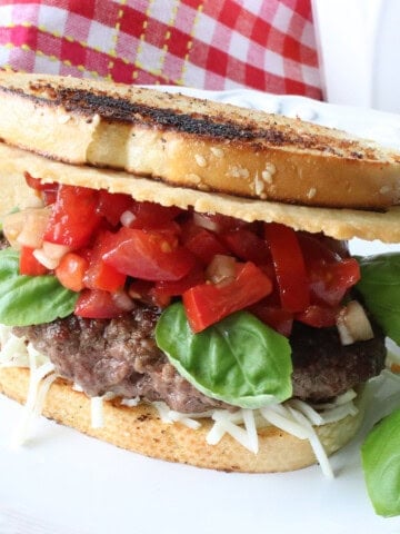 A Bruschetta Burger on Italian Bread with tomatoes, basil, and a Parmesan crisp.