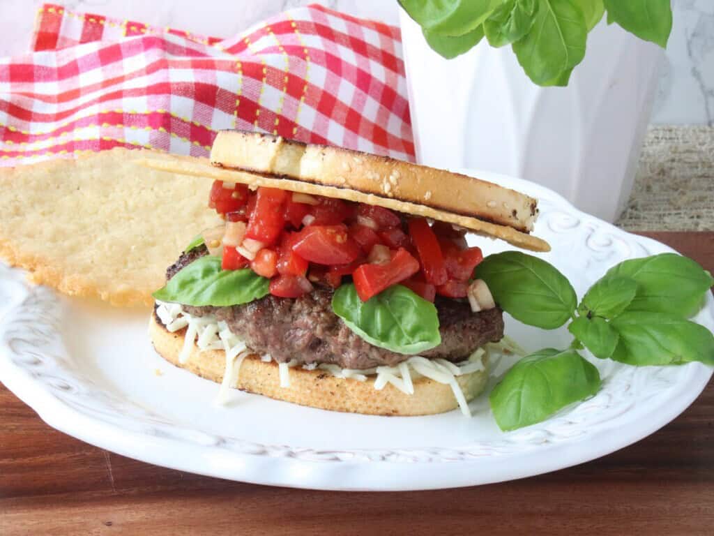 A Bruschetta Burger topped with tomato relish, basil, Parmesan crisp and bread.
