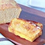 Two slices of toasted English Muffin Bread on a wooden cutting board.