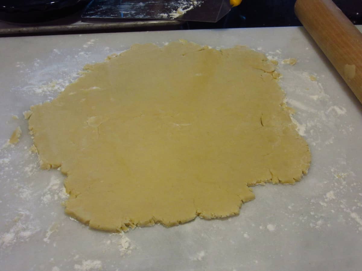 A rolled out pie crust on a floured surface.