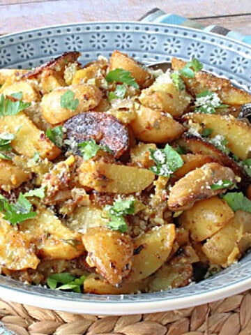 A blue bowl filled with Hot Roasted Potato Salad.