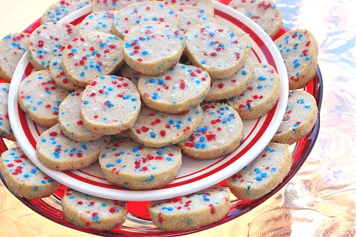 A two tiered plate of cream cheese cookies with Patriotic sprinkles 