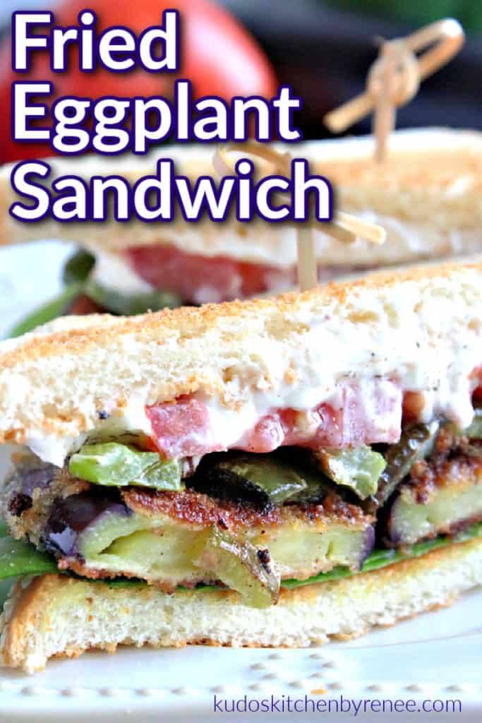 A vertical closeup of the inside of a fried eggplant sandwich with mayo, lettuce, and tomato and a title text graphic overlay. Fried Eggplant Sandwich recipe