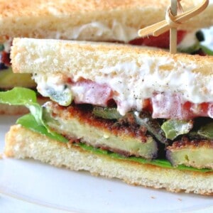 A Fried Eggplant Sandwich on toast with mayo, tomatoes, lettuce and green peppers.