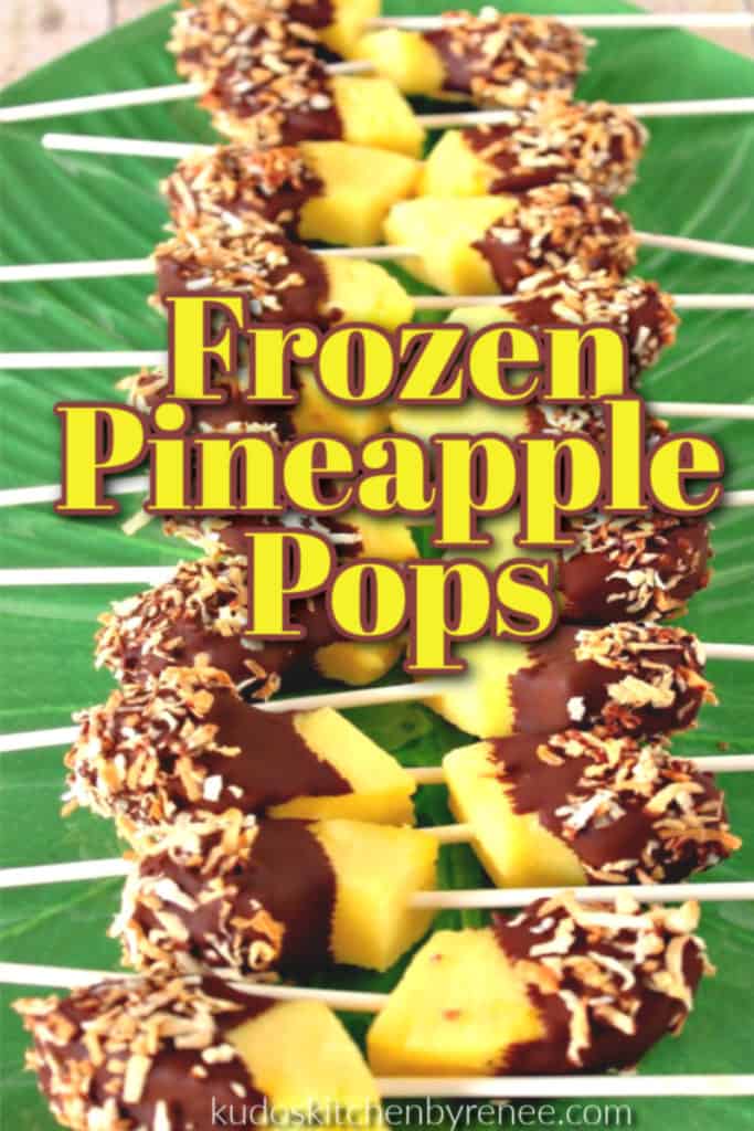 A row of frozen pineapple pops on a green platter with chocolate and coconut with title text overlay graphic