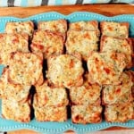 A blue plate filled with Parmesan onion appetizer squares.