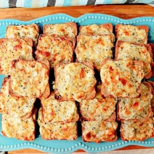 A blue plate filled with Parmesan onion appetizer squares.