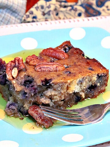 A slice of Sausage Blueberry Breakfast Cake on a blue and white polka dot plate.